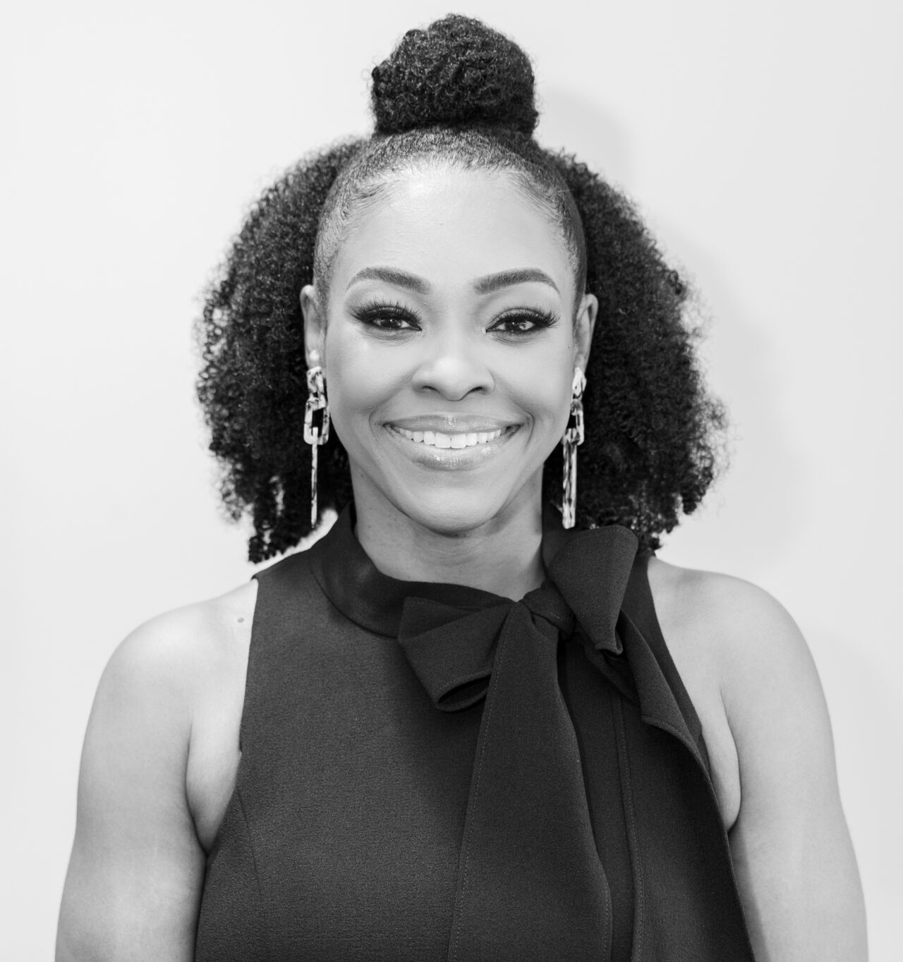 Smiling woman with smooth skin and natural curls, showcasing cosmetic skincare results at a Birmingham dermatology clinic