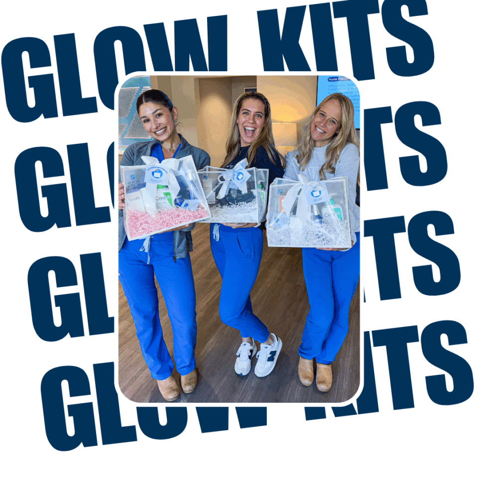 Three dermatology staff in blue scrubs smiling and holding skincare 'Glow Kits' gift baskets