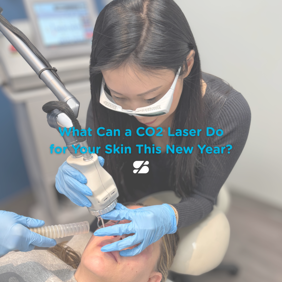 A woman clinician wearing magnifying eyewear and gloves performs CO2 laser treatment on a patient's face