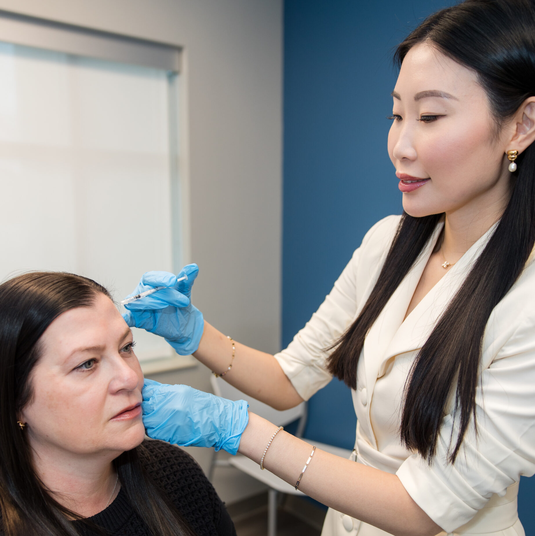 Clinician administering cosmetic injectable to patient's forehead in a dermatology office in Birmingham, AL