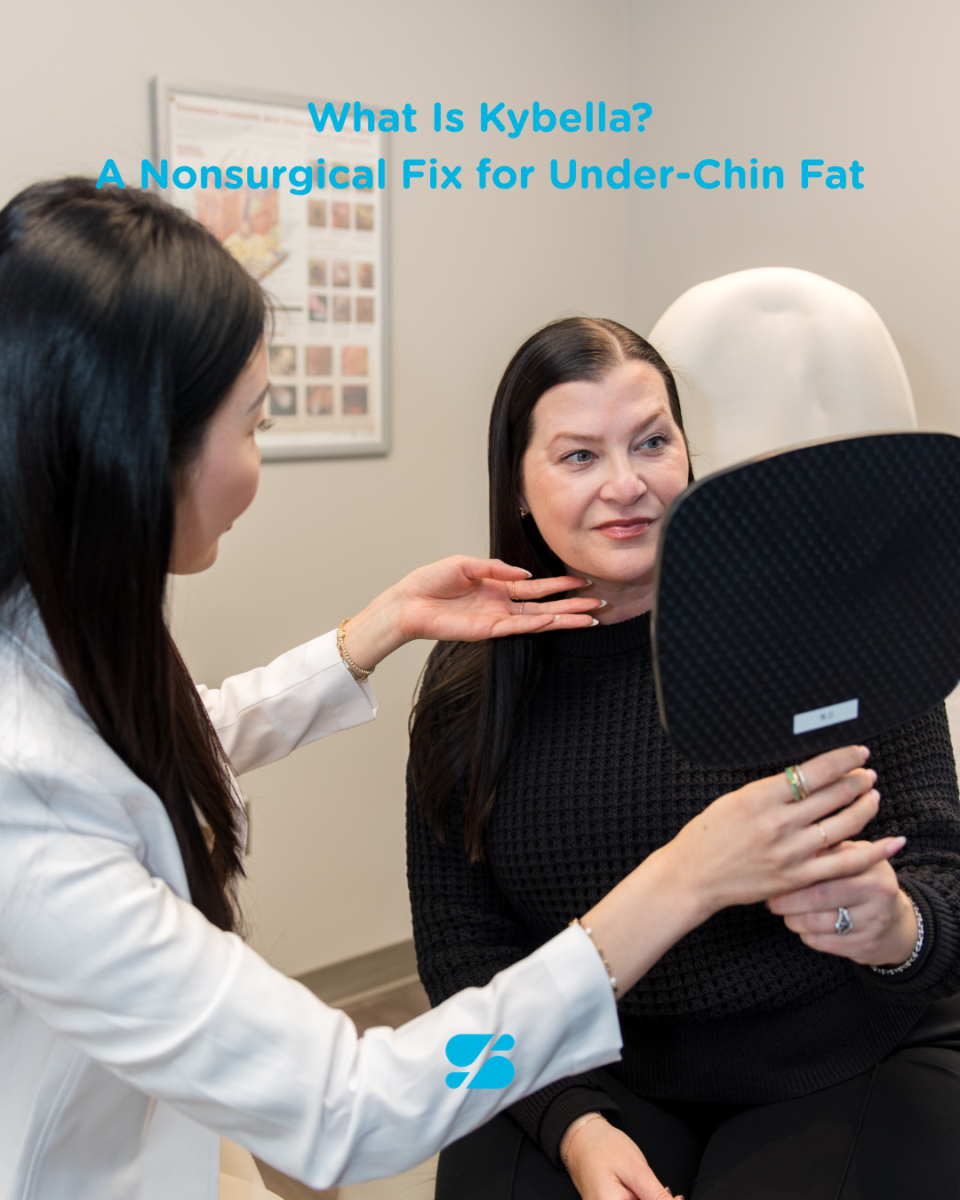 Doctor consulting a patient about under-chin Kybella treatment as she checks results in a mirror