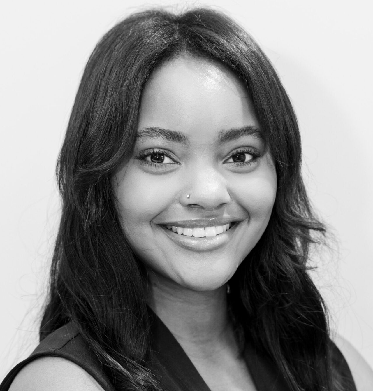 Smiling woman close-up headshot showcasing clear skin, bright eyes and subtle nose piercing for Birmingham skincare clinic.
